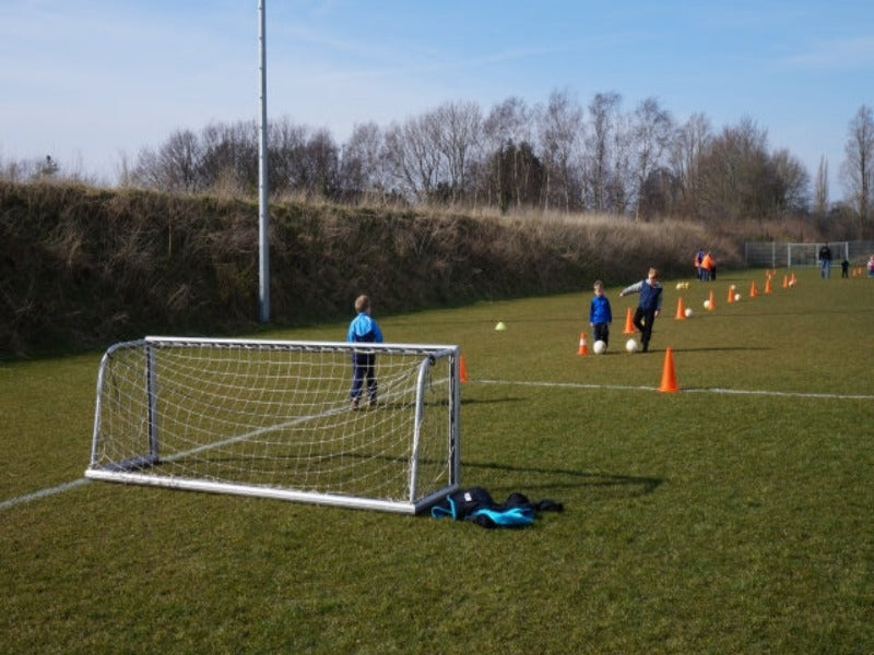 kinderen spelen voetbal met een minidoel