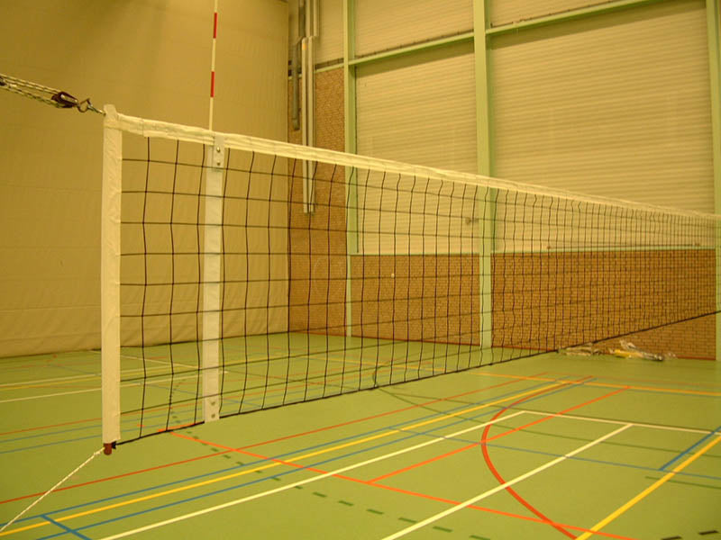 volleybalnet met houten stokken in een gymzaal